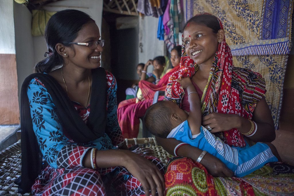 Sumi Madhi, voluntaria de lactancia, nutrición y cuidado infantil, interactúa con una madre en Kudada, India, donde hay 1250 hospitales acogedores.