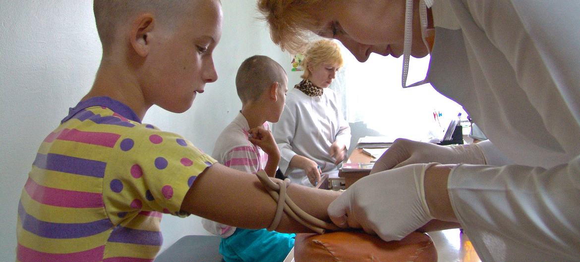 Un médico examina a un niño para detectar el VIH en Ucrania.