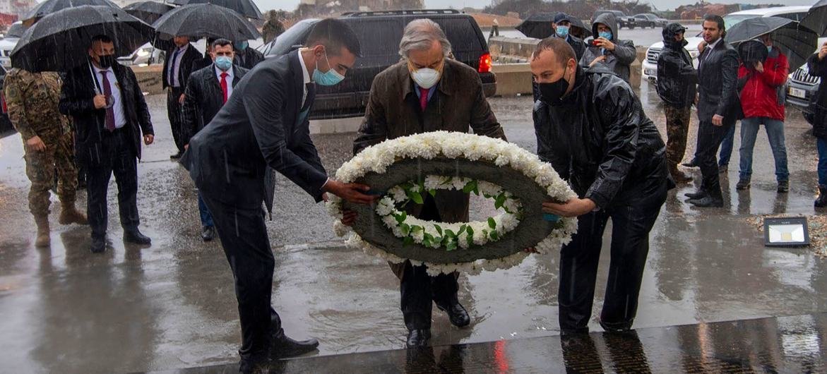 El secretario general António Guterres (centro) coloca una ofrenda floral para las víctimas de la explosión en el puerto de Beirut.