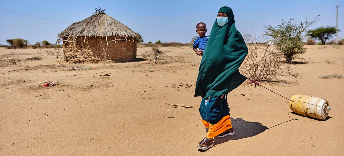 Una mujer intenta conseguir agua con su hijo de dos años en Garissa, Kenia.