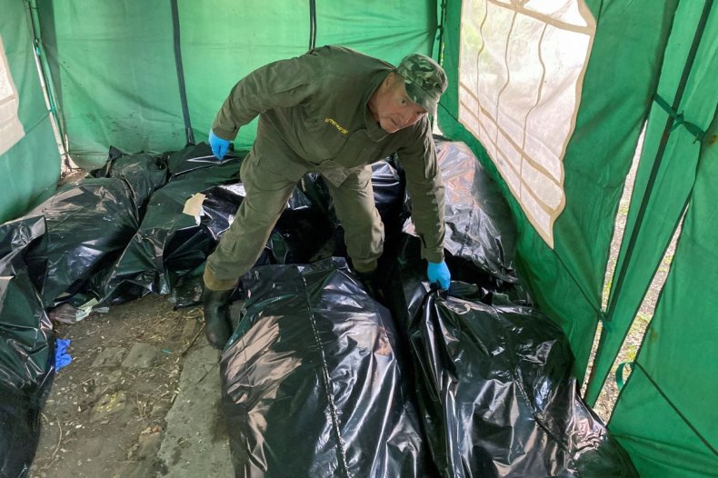 Un trabajador ritual recoge el cuerpo de un soldado ruso asesinado antes de cargarlo en un vagón refrigerado, mientras continúa el ataque de Rusia contra Ucrania, en un recinto de una morgue en Kharkiv, Ucrania, el 22 de mayo de 2022.  