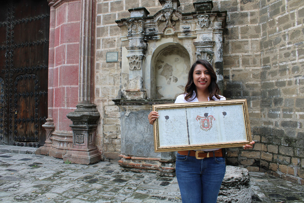 Angélica Alvardado muestra el escudo de armas de Huejotzingo.