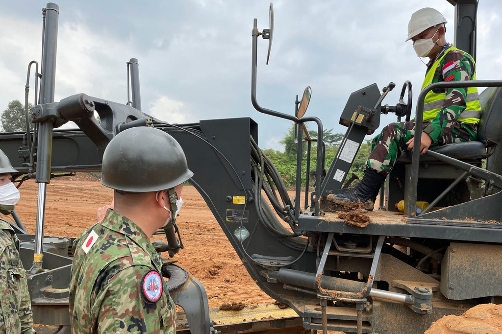 Un instructor militar japonés ayuda a un soldado del 3er Batallón de Ingeniería de Combate del Ejército de Indonesia a perfeccionar sus habilidades para conducir una motoniveladora, equipo que necesitará para operar la misión de mantenimiento de la paz...