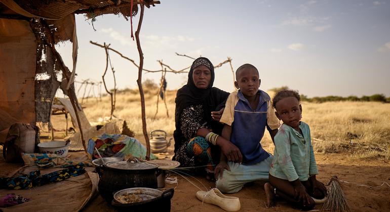 Una familia desplazada se sienta frente a su tienda de campaña en un campamento informal en Bagoundié, Malí.