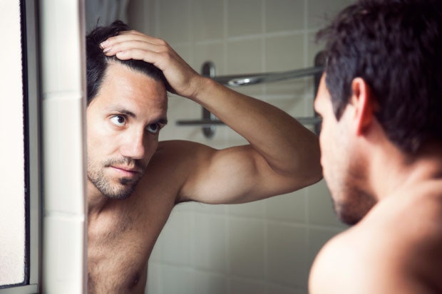 Hombre con cabello negro frente al espejo