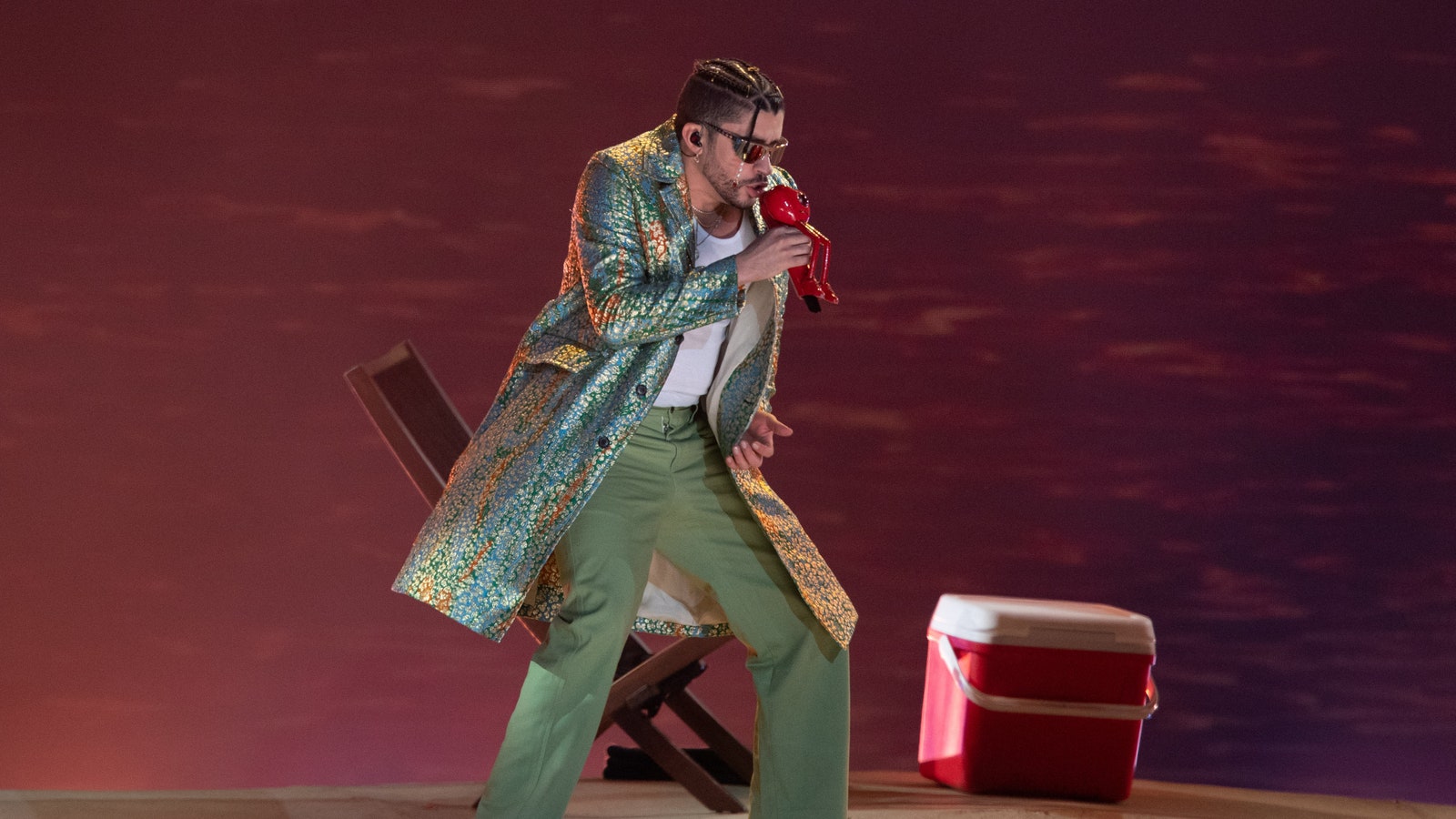 Bad Bunny viste abrigo y pantalón verde en concierto