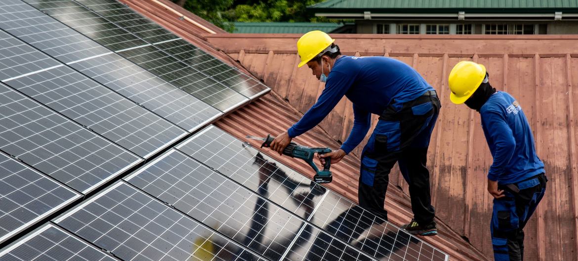 Los trabajadores de PHILERGY, un proveedor e instalador de energía solar filipino-alemán, instalan paneles solares en una casa en Manila, Filipinas.