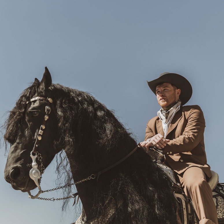 Saul Canelo Alvarez montando un caballo negro