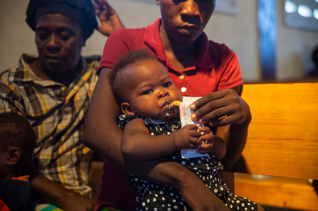 Un niño haitiano con desnutrición aguda severa tomando un suplemento nutricional.