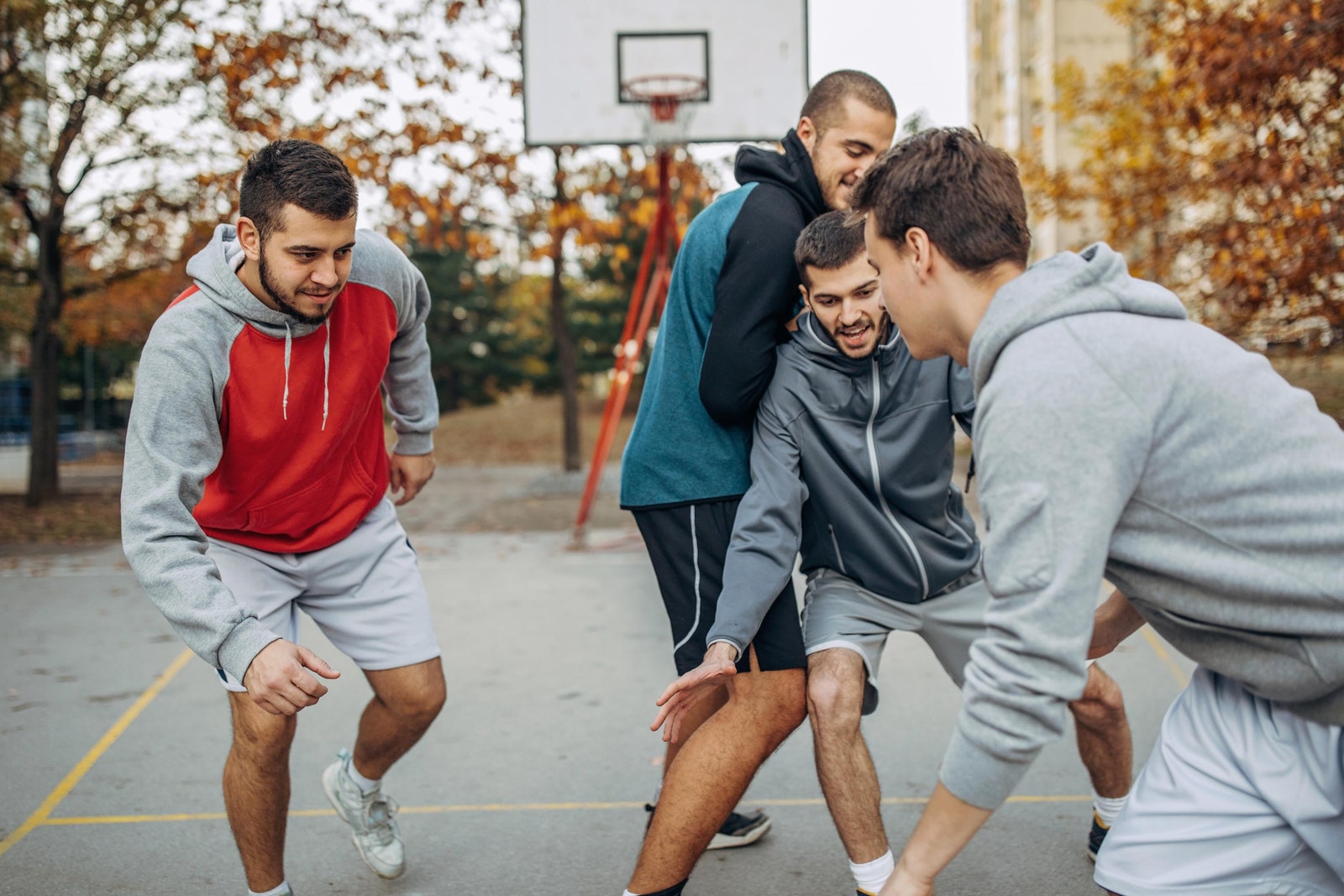 Grupo de amigos jugando baloncesto practicando actividad física.