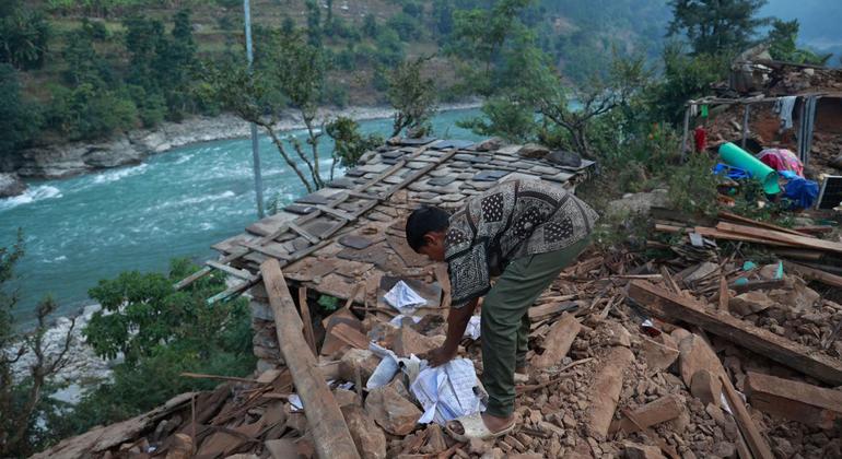 Un niño busca entre los escombros de su casa afectada por el terremoto en West Rukum, Nepal.
