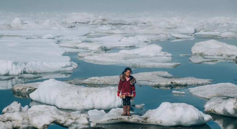 Una niña camina a través de las capas de hielo del Ártico en Barrow, Alaska.  La pérdida de hielo en el Ártico es uno de los muchos efectos del calentamiento global.